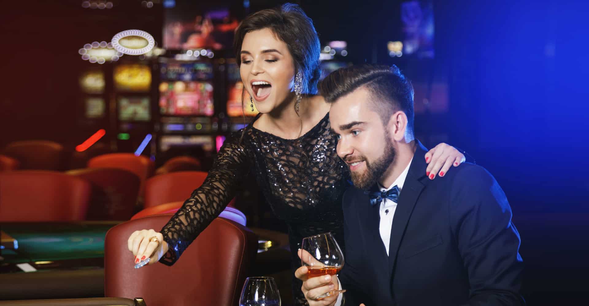 Couple dressed formally holding drinks at the casino table