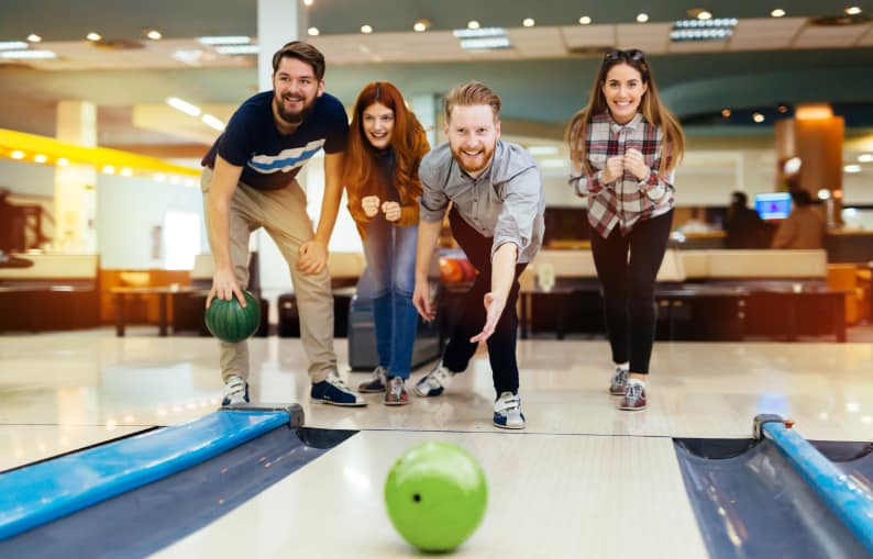 Four people playing at the Bowling Alley