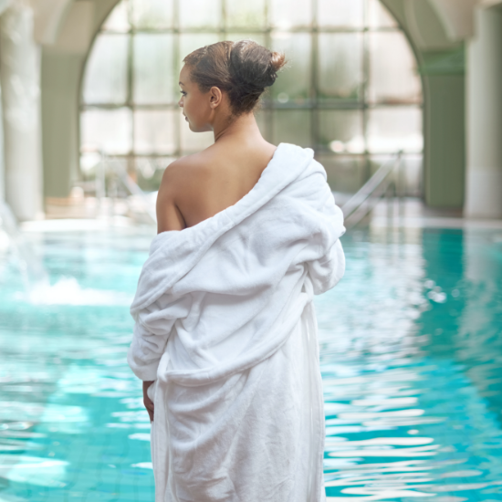 Lady wearing a white gown infront of the spa pool